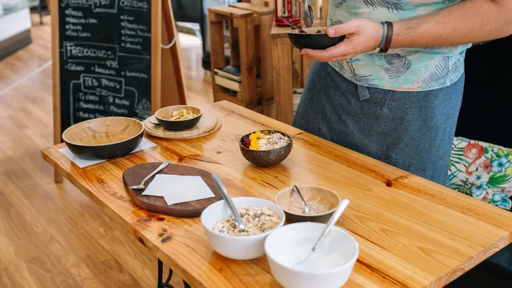 A wooden counter in a bright cafe set with bowls of a fresh, simple meal.